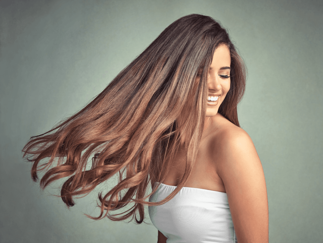 Smiling woman with long, softly blended brunette balayage, styled in natural waves – Michael Todd Hairdressing