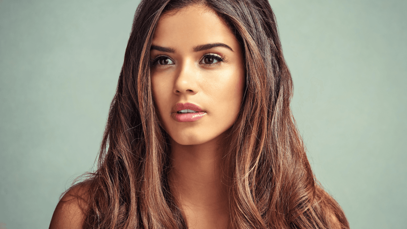 Model with glossy brunette balayage hair styled at Michael Todd Hairdressing, East Grinstead, showcasing expert colour services and natural, elegant results